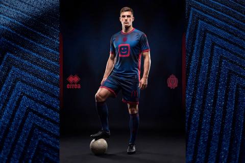 KV Mechelen third shirt featuring a blue and red design by Erreà, worn by a model.