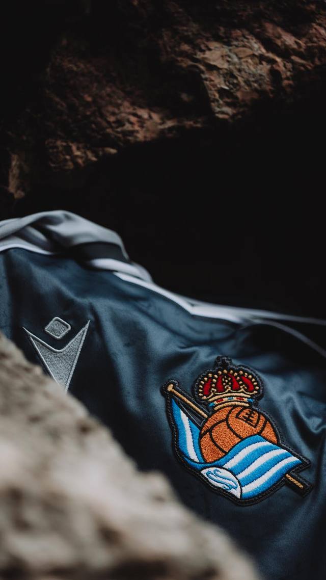 A close-up detail of the Real Sociedad 2025/26 away shirt, showing the club crest and the Macron logo.