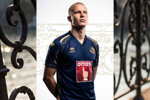 A model wearing the navy and gold FC Luzern home shirt.