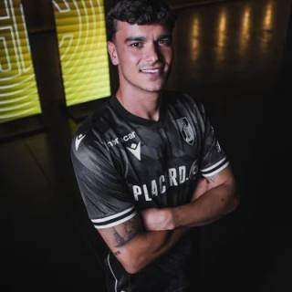 A player posing in the black Vitória SC away shirt.