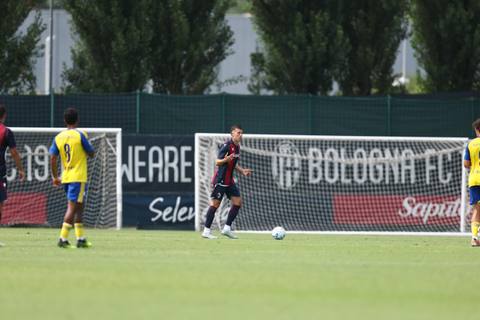 Bologna FC player wearing the navy and red home shirt on the pitch during training.
