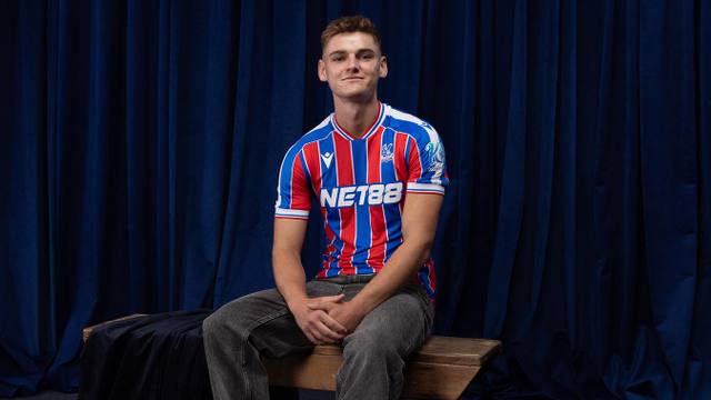 A player wearing the Crystal Palace FC home shirt with red and blue stripes.
