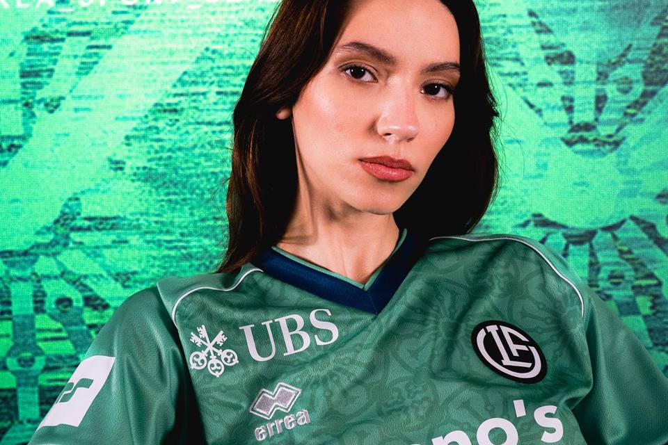 A model wearing the green FC Lugano third shirt by Erreà.