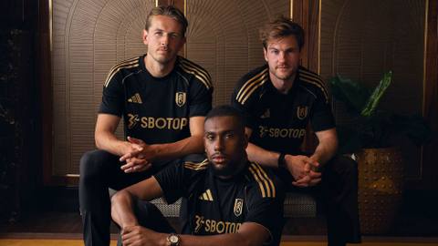 Three Fulham FC players present the club's 2025/26 third shirt, featuring a black design with gold details.