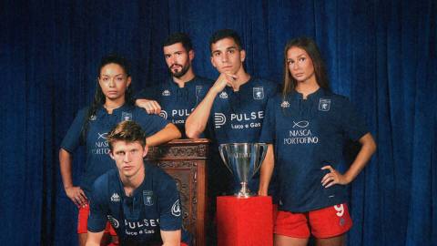 Models wearing the dark blue Genoa CFC third shirt with red shorts in a promotional photoshoot.
