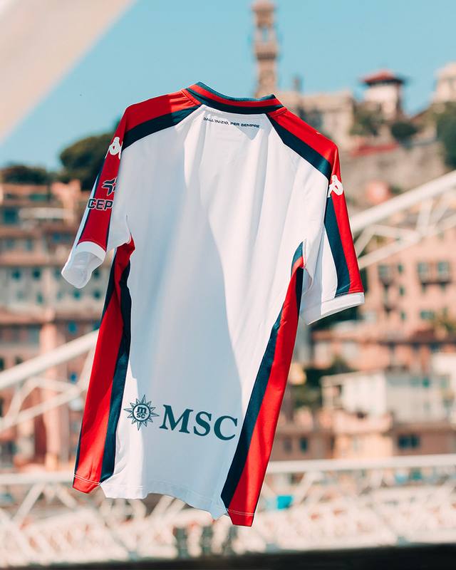 The back of the Genoa CFC 2024/25 away shirt, hanging in front of a blurred cityscape.