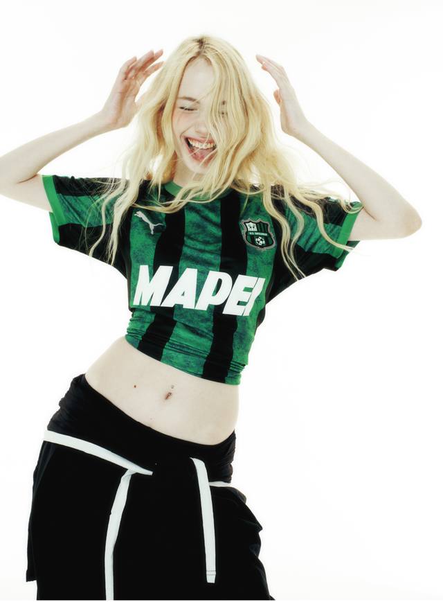 A studio portrait of a model wearing the green and black striped U.S. Sassuolo Calcio home shirt.