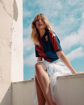 A model wears the Genoa CFC 2024/25 home shirt during a campaign photoshoot.