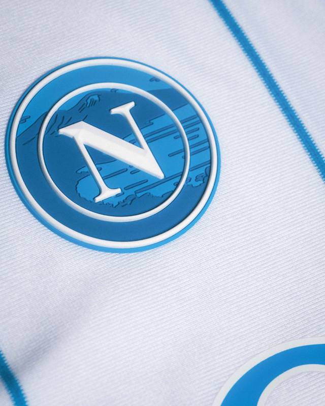 A close-up detail of the SSC Napoli crest on the white away shirt.
