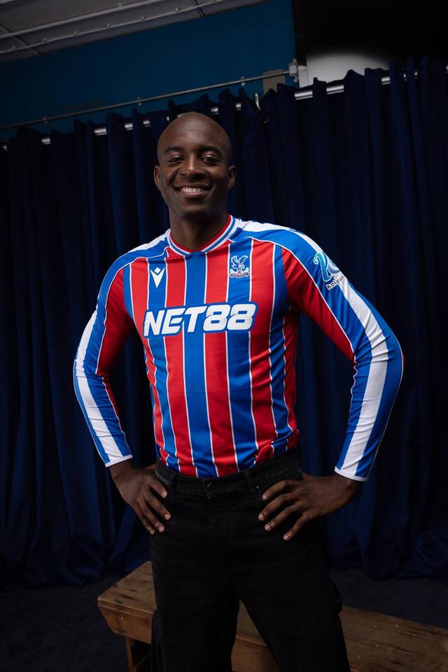 A model posing in the Crystal Palace FC 2025/26 home shirt