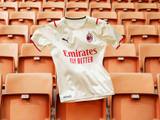 An AC Milan away shirt displayed against orange stadium seating.